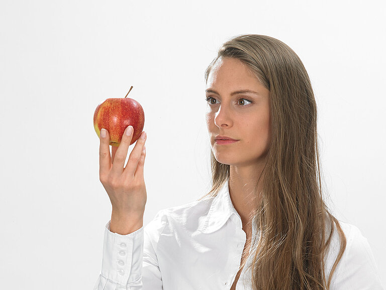 Lacon Stella schaut roten Apfel an 